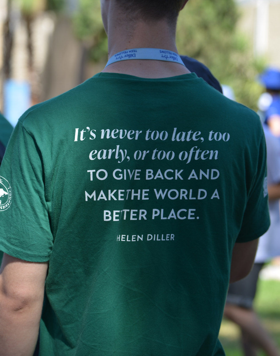 Photo of the back of a t-shirt that reads "It's never too late, too early, or too often to give back and make the world a better place."